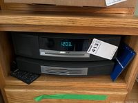 Front view of Bose Wave Music System console and stacked CD changer in wooden shelf