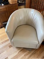 Front-facing view of light beige leather bucket swivel chair.