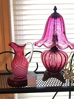 Lamp and jug displayed side by side on metal shelf