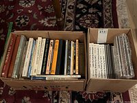Two cardboard boxes filled with assorted fishing books
