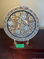 Front view of round metal plate with floral and bird design