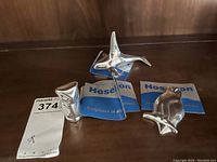 Three polished aluminum sculptures by Hoselton displayed together with their documentation.