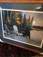 Full view of the framed limited edition print showing two Adirondack chairs on a lakeside dock with autumn trees.
