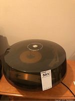 Closed view of Electrohome round record player with black base and clear dust cover showing the brand label.