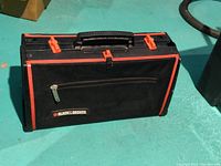 Closed view of Black and Decker tool bag showing hard plastic and fabric construction with zipper and handle.