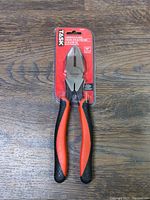 TASK Tools 10 inch Linesman Pliers, new, in original red packaging showing pliers with orange and black handles on a wood surface.