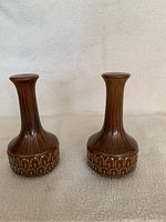 Close-up photo of the brown Wedgwood salt and pepper shakers showing the textured geometric arch pattern on the base and ribbed neck design.