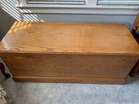 Full view of the wooden chest showing the exterior wood grain and finish