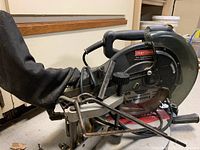Left side view of the Craftsman 10-inch compound mitresaw showing dust bag, handles and blade.