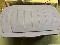 Closed large light purple Rubbermaid plastic container with a lid?