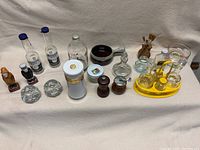 Photo showing full collection of miscellaneous kitchen ware items including pepper grinders, small shaker sets, candle holders, and vintage bottles.