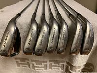 Front view of Adams Golf irons 4-9 and pitching wedge showing club heads and branding