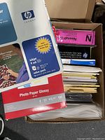 Box with HP glossy photo paper, photo paper glossy, folders and pink CD labels on top