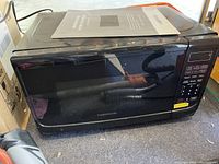 Photo of a black Farberware microwave with digital keypad and tinted front door window.