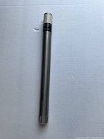 Photo of a solid tungsten cylinder on white background showing metal rod with label 'TUNGSTEN 95 OZ' near one end