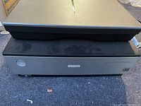 Front view of closed scanner showing front panel with Epson branding, power button, V850 Pro model name and ICE logo
