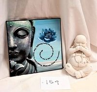 Both Buddha plaque and seated laughing Buddha statue shown together on fabric background.