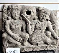 Front view of the rectangular concrete garden piece showing two carved seated figures and central water hole.