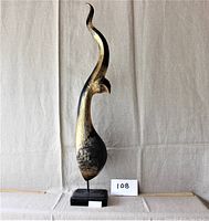 Front right angle view of wood chofa sculpture on base