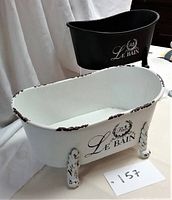 Photo of the white and black metal bathtub-shaped planters showing their size and style.