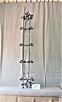 Full front view of the vertical, wall-mounted metal plate display rack against a cloth background.