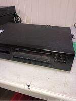 Front view of the black Rotel CD player with buttons and display screen.