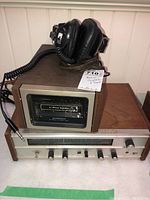 Photo showing Realistic receiver with Pioneer 8 track stereo deck on top and coiled wired headphones resting on equipment.