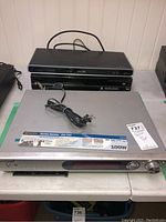 Kenwood Fineline Receiver VRS-7100 silver audio control center with Philips black DVD player placed on top back to back