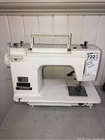 Front side view of Janome 722 white sewing machine with handle, needle area, and base visible.