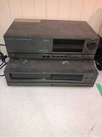 Front view showing stacked Mitsubishi tuner-preamplifier on top and CD player below on a white surface.