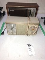 Sony and General Electric radios placed side by side on a white surface. Sony radio features wooden casing, control knobs, and speaker grill. GE clock radio includes large clock face and tuning dial.