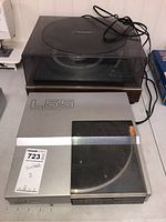 Two turntables together, showing Hitachi L55 with silver base and Lloyds wooden base turntable.