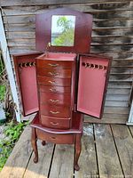 Chest open: side doors flared, central drawers exposed, mirror raised