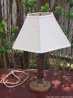 Full view of the lamp showing the fabric shade with embroidered floral pattern and cord attached.