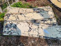 Stack of cream-painted pressed tin panels showing front embossed floral medallions and honeycomb pattern