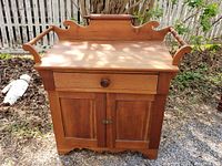 Front view of entire washstand showing backsplash, towel rails, drawer and cabinet doors