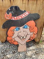 Front view of the vintage hand painted witch holiday wooden decoration showing detailed facial features and black hat with pumpkin.