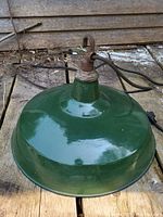 Top angle showing green enamelware hanging shade with attached rusty metal hook and black wiring.