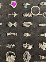 Close-up view of 20 assorted rings in a black insert showing variety in design and stone colors.