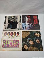 Front view of 4 vinyl LP albums including The Beatles Flowers, Rubber Soul, and White Album plus John Lennon Live in New York City showing cover art.