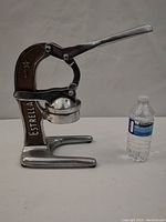 Front view of Estrella citrus juicer next to a water bottle for size reference.