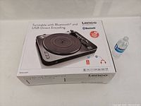Lenco LBT-120BK turntable in original box with Bluetooth and USB direct encoding features shown on packaging.