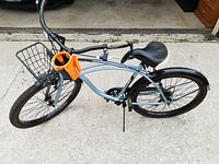 Left side overview of men's Huffy cruiser bicycle showing front basket, cup holder, frame and tires.