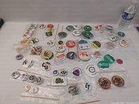 Overview of the miscellaneous metal buttons laid out on a table, showing the diversity and variety of buttons included in the lot.