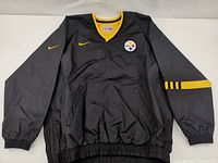 Front view of the black Nike Pittsburgh Steelers windbreaker jacket with yellow accents and logos.