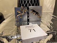 Two animal-themed brooches displayed on their backing cards with 'Handcrafted in Thailand' text visible, placed behind a MaxSold auction number card.