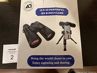 Front box of Adasion 12x42 HD Binoculars showing product image and slogan.