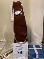 Bright 21k gold electroplated necklace displayed on brown leatherette necklace display stand, showing chain length and clasp detail.