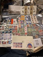 Overview of many unused Canadian postage stamps arranged on a surface including commemorative covers and single stamps.
