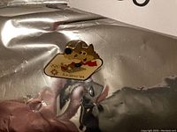 Pin featuring 1984 Sarajevo Olympics mascot in enamel metal with cartoon dog on skis and red scarf